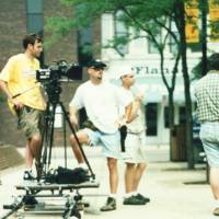 a camera team of three guys setting up the shot on a dolly track